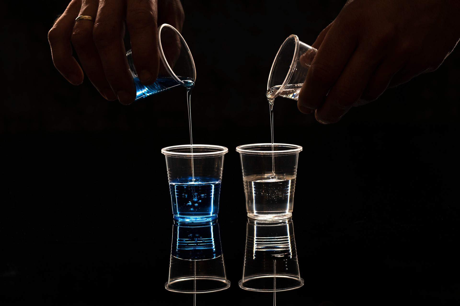 Mixing blue and clear resin components for composite materials – illustrating precision and chemistry in resin preparation.